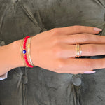 Hand with rings and bracelets on a gray textured surface