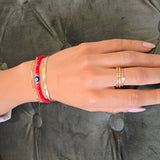 Hand with rings and bracelets on a gray textured surface