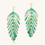 Green leaf-shaped earrings on a white background