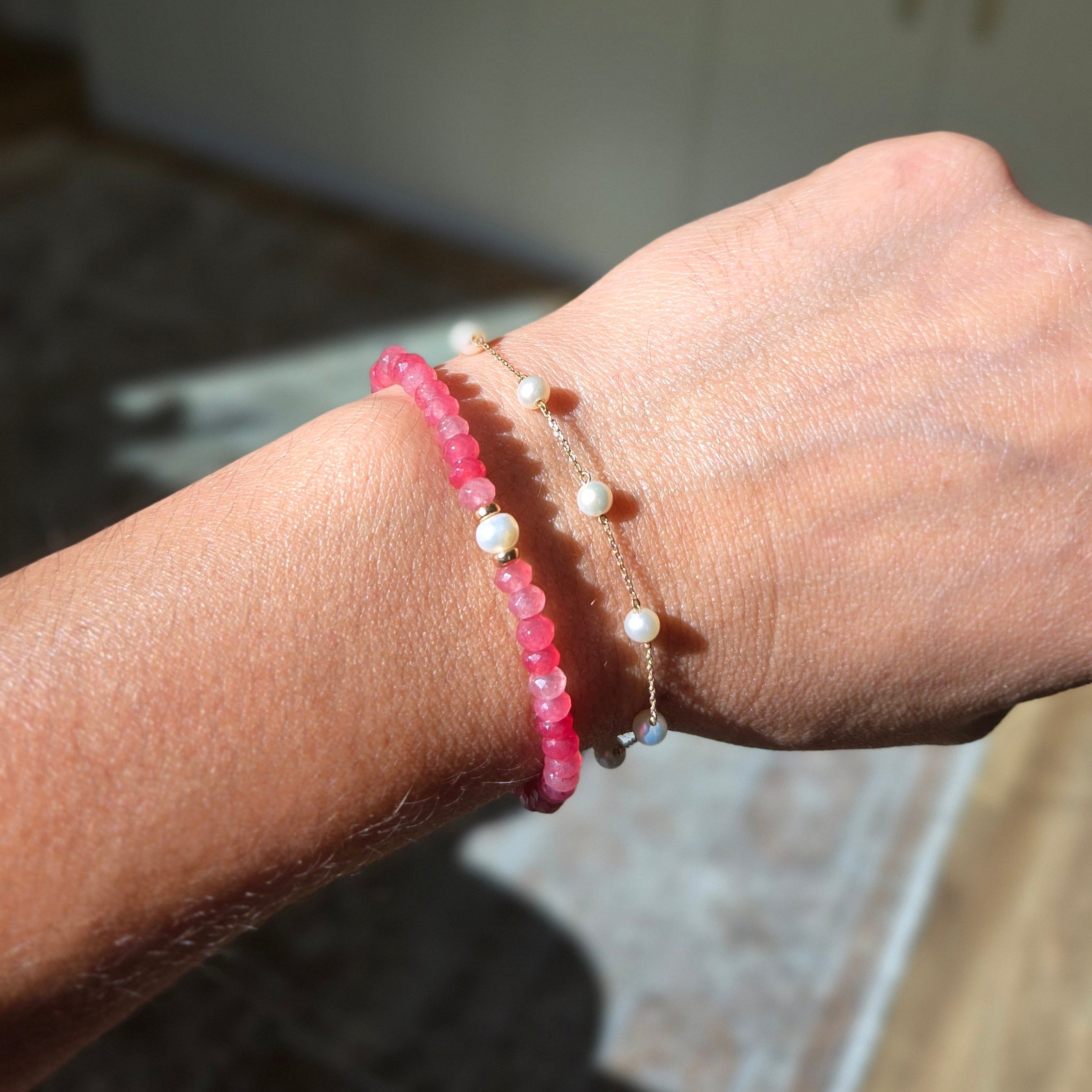 Close-up of a wrist wearing two bracelets with a blurred background