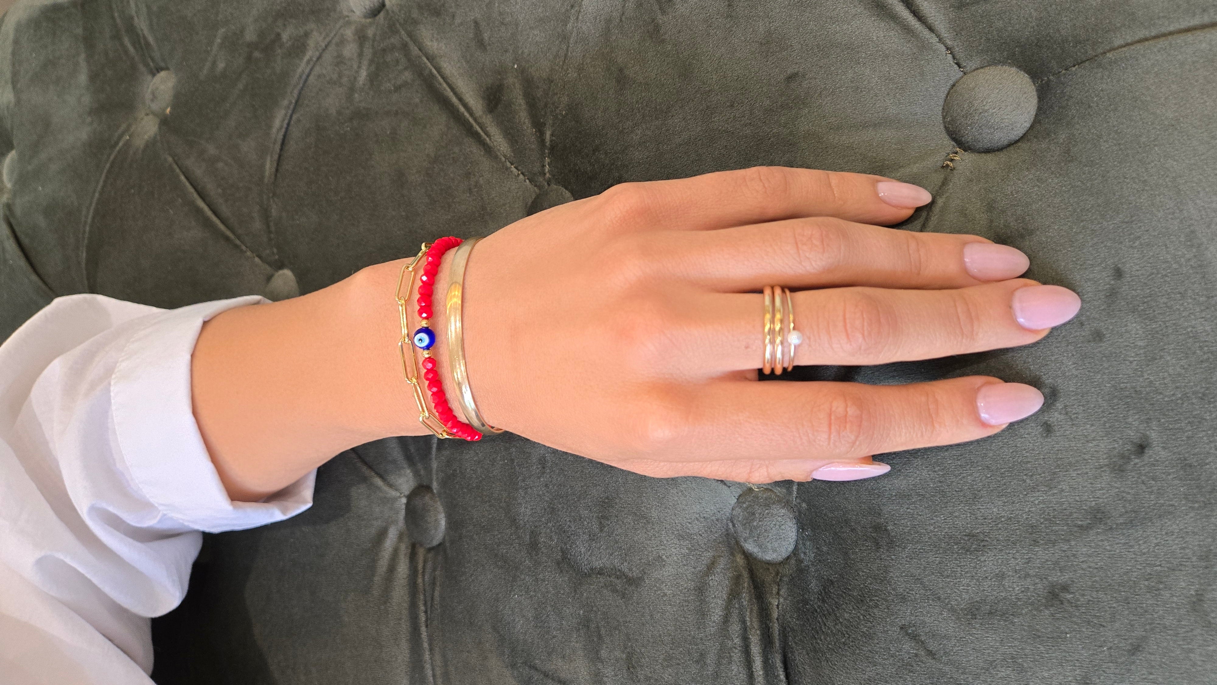 Hand with rings and bracelets on a gray textured surface