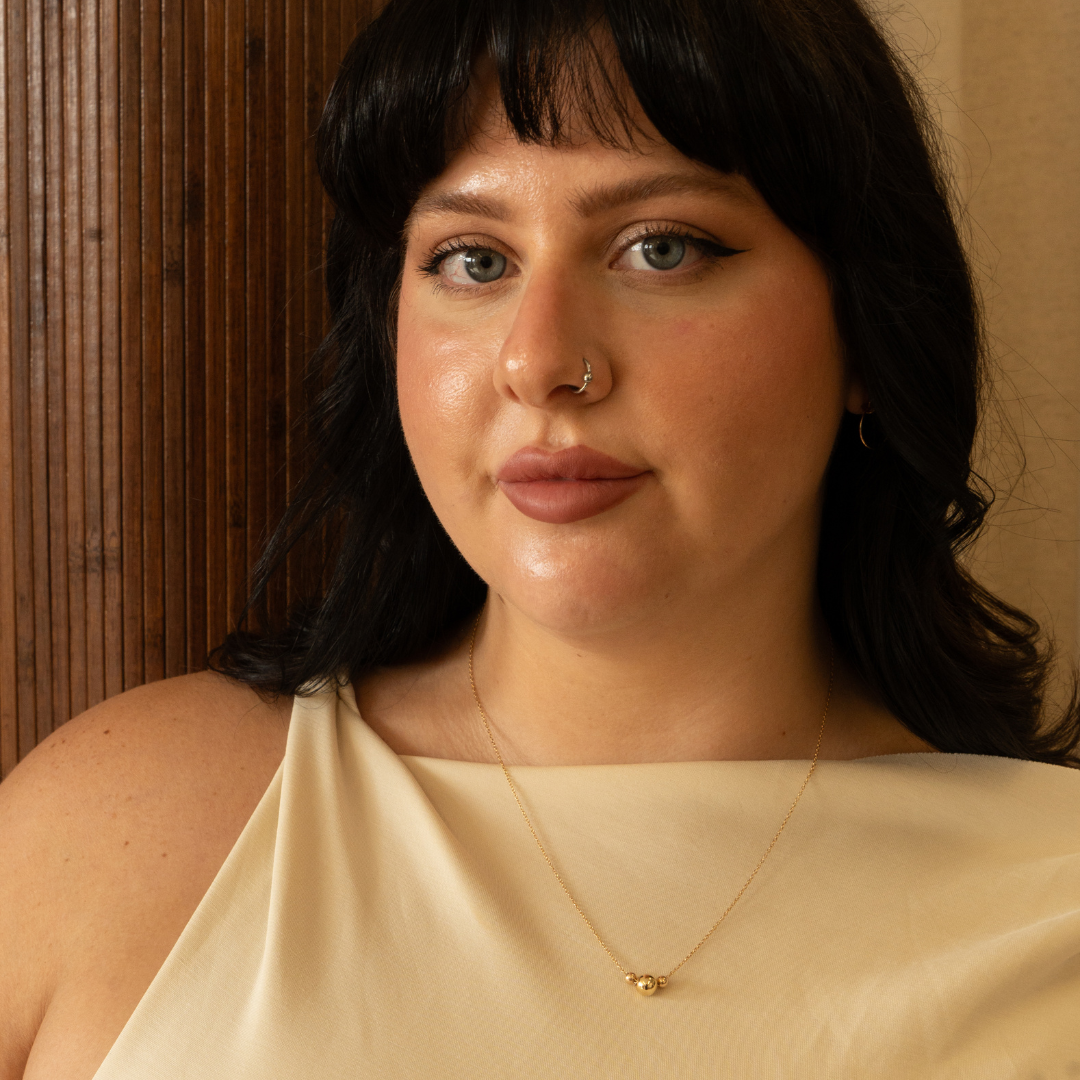 model wearing gold filled ball necklace on beige top