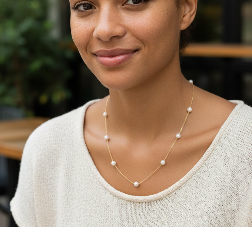 Gold necklace with pearls on a white background