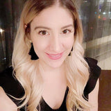 Woman with blonde hair and a black top in an indoor setting