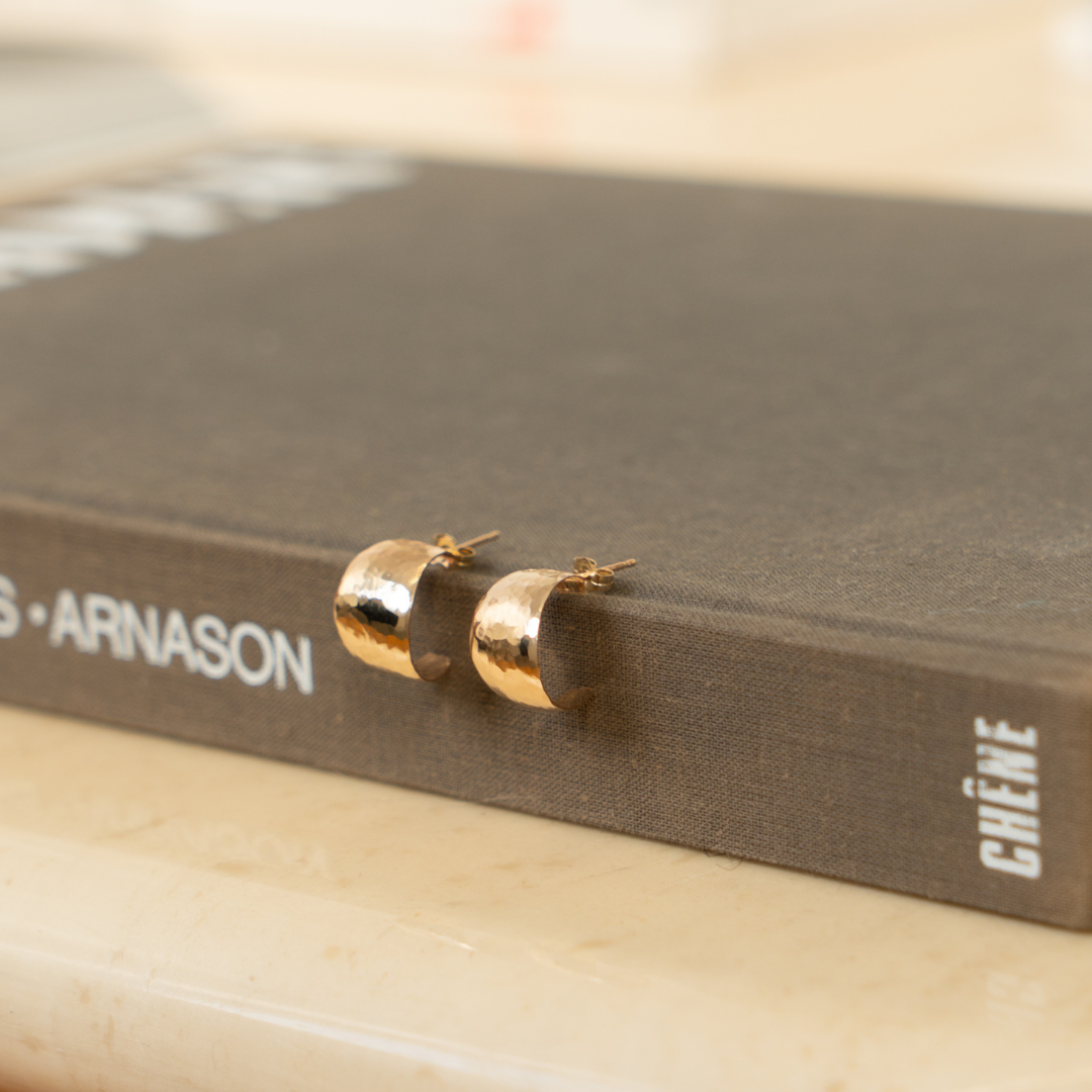 hammered earrings styled on a book