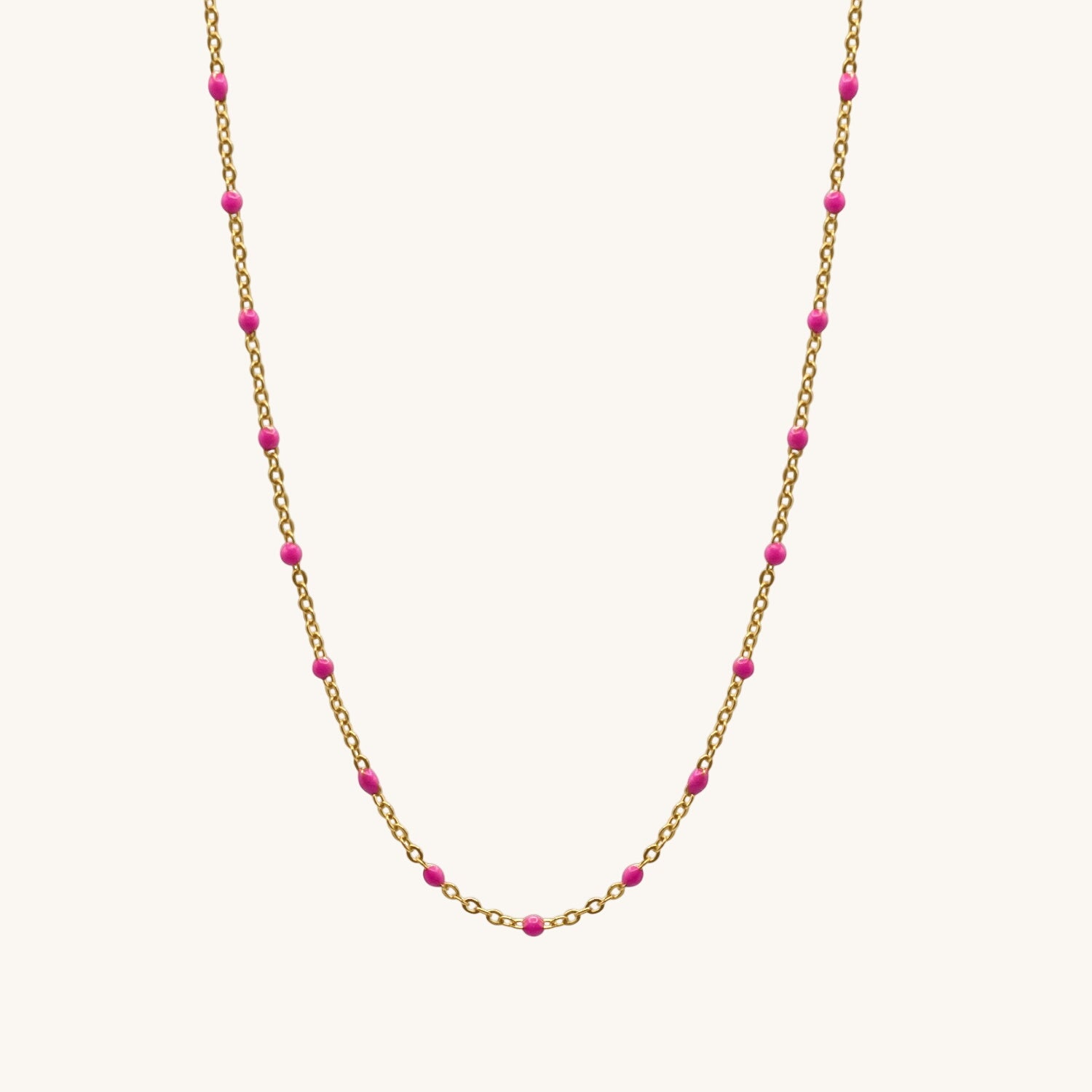 Necklace with gold chain and pink beads on a white background
